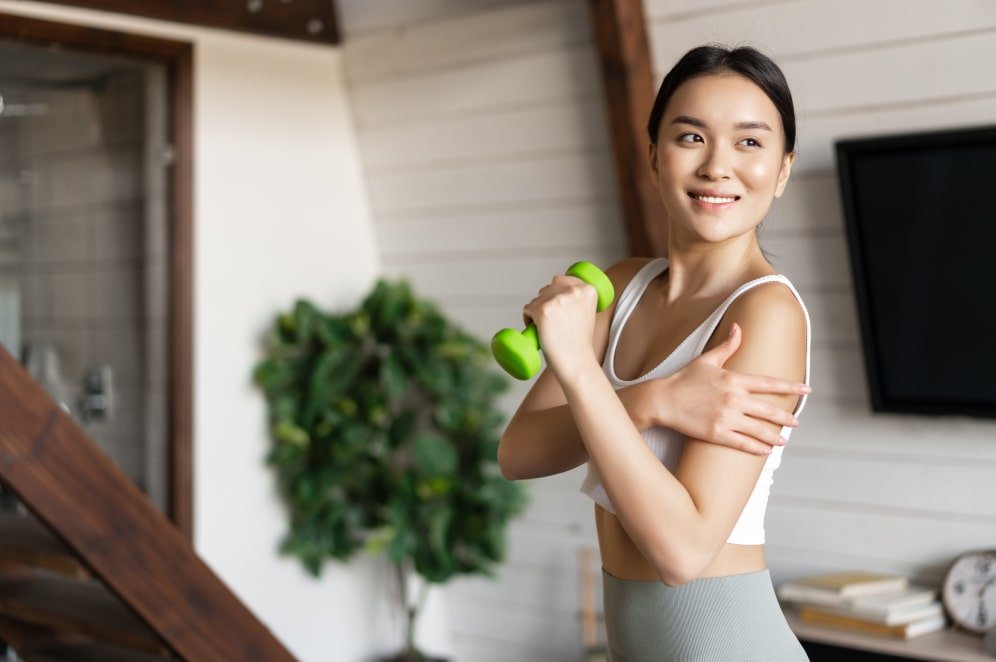 active-healthy-asian-girl-with-fit-body-doing-fitness-exercises-home-lifting-dumbbells (1)-min