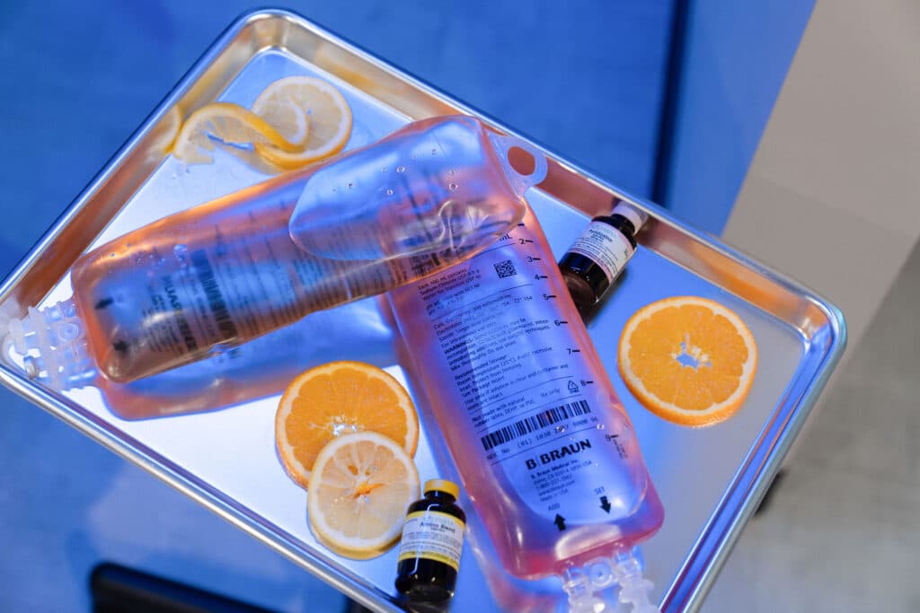 IV vitamin infusion bags and supplements displayed with fresh orange slices